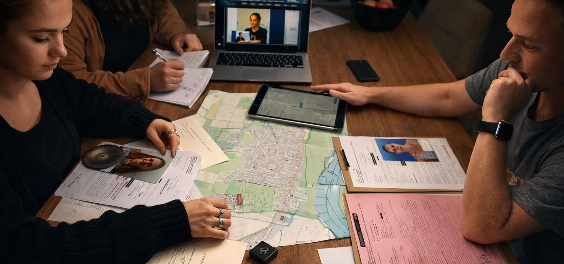 Fysieke Unsolved Case File Game met bewijsstukken op tafel